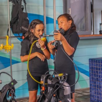 This picture shows two kids during a bubblemaker course. The picture is featured by your Gili Meno dive center Divine Divers. Diving Gili Islands for beginners and experts. Fun Diving and courses and introduction dives. Accommodation and healthy restaurant on Gili Meno.